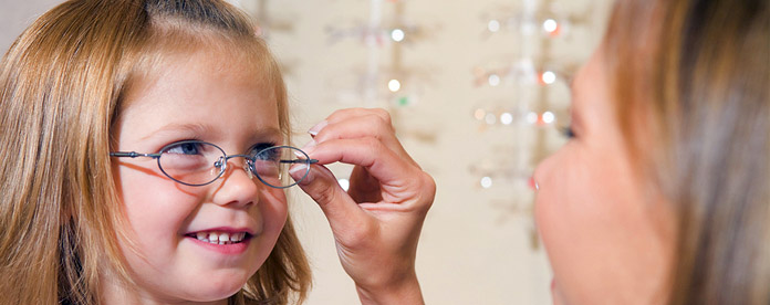 A young girl trying on a pair of glasses
